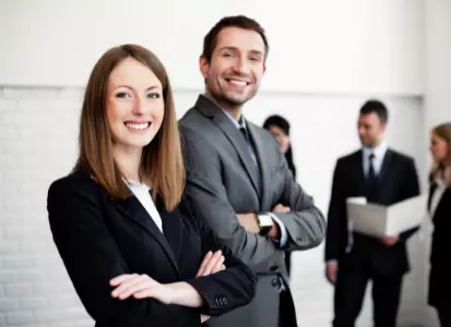 Business People im Anzug/Hosenanzug, die lächelnd in die Kamera blicken