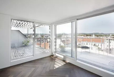 Dachgeschossausbau in der Schopenhauerstraße in Wien, man sieh die Terrasse und Wohnraum mit dunklem Boden