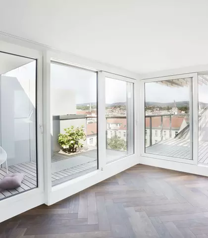 Dachgeschossausbau in der Schopenhauerstraße in Wien, man sieh die Terrasse und Wohnraum mit dunklem Boden
