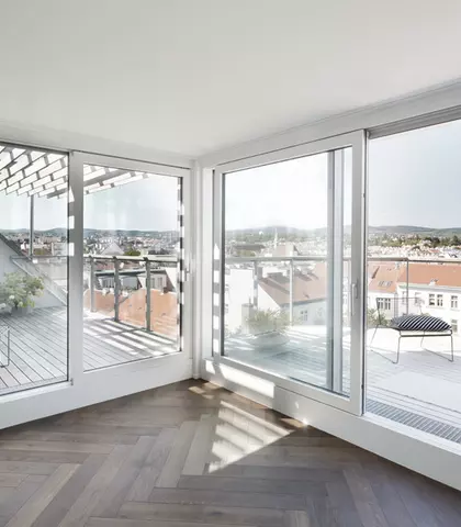 Dachgeschossausbau in der Schopenhauerstraße in Wien, man sieh die Terrasse und Wohnraum mit dunklem Boden